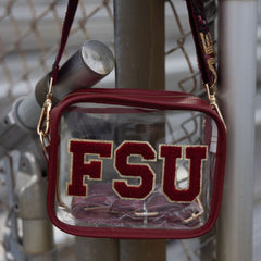 Clear bag with red 'FSU' letters hanging on a metal fence.