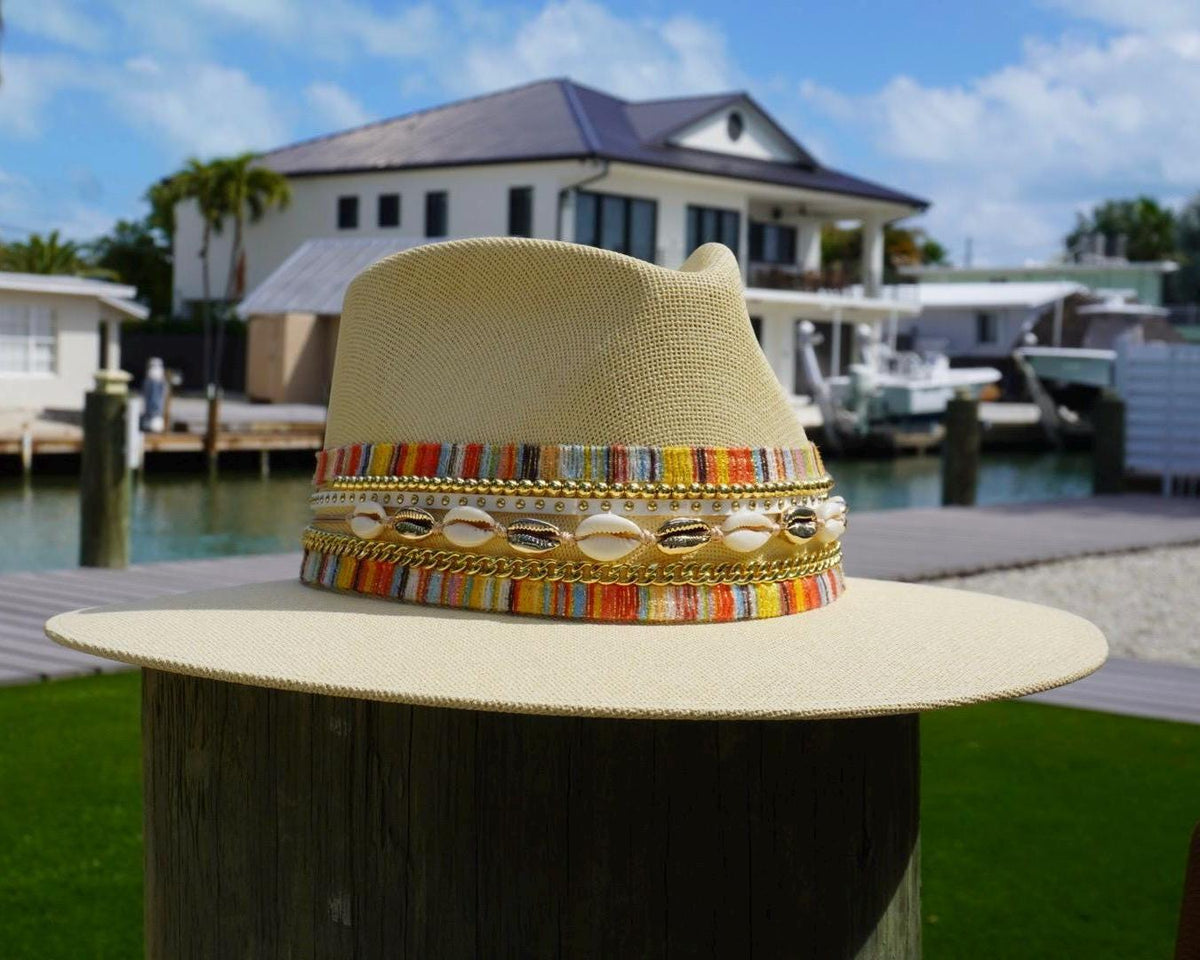 Women’s waterproof wide brim boater hat by Sunkissed by Chrissy with straw material, shell band, gold accents, perfect for beach and resort wear.