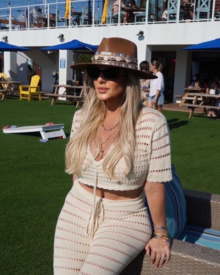 Sunkissed by Chrissy women's wide brim boater hat with straw material, gold embellishments, and shell band, perfect for beach or resort wear.