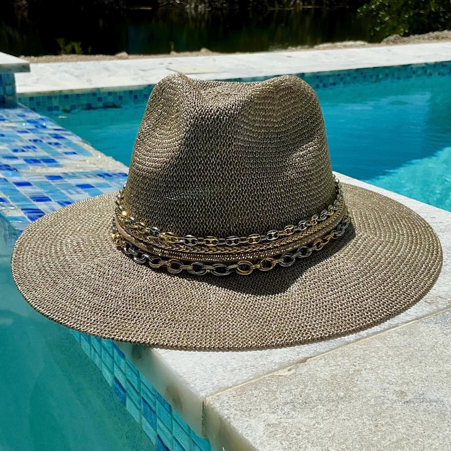 Mixed metal Panama-style sun hat with wide brim, gold and silver chain, designed for women’s beach and resort wear.